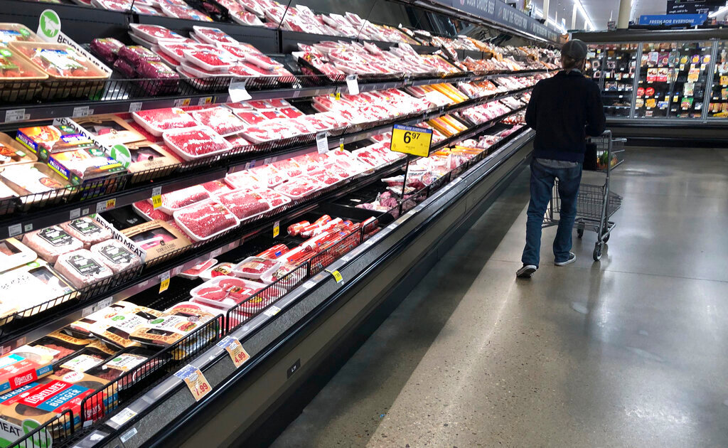 A shopper passes a display of packaged meat in a grocery store in southeast Denver, May 10, 2020. (AP Photo/David Zalubowski, File)