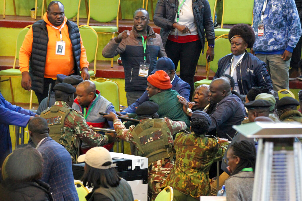 Scuffles break out between political party agents and police, including presidential candidate Raila Odinga's chief agent Saitabao Ole Kanchory, center left in grey and red jacket, at the electoral commission's national tallying center in Nairobi, Kenya late night Saturday, Aug. 13, 2022. (AP Photo)