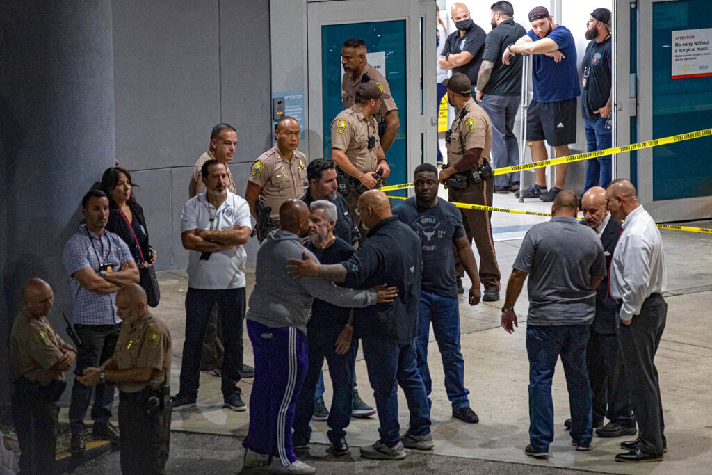 Police officers and other officials stand outside the Ryder Trauma Center after a Miami-Dade police officer was shot in an exchange of gunfire during a car chase with an armed robbery suspect Monday, Aug. 15, 2022, in Miami. (Sydney Walsh/Miami Herald via AP)