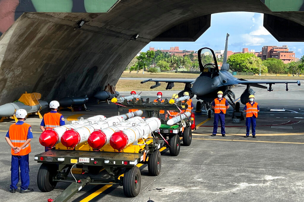 Military personnel stand next to Harpoon A-84 anti-ship missiles and AIM-120 and AIM-9 air-to-air missiles prepared for a weapon loading drills in front of a F16V fighter jet at the Hualien Airbase in Taiwan's southeastern Hualien county on Wednesday, Aug. 17, 2022. (AP Photo/Johnson Lai)