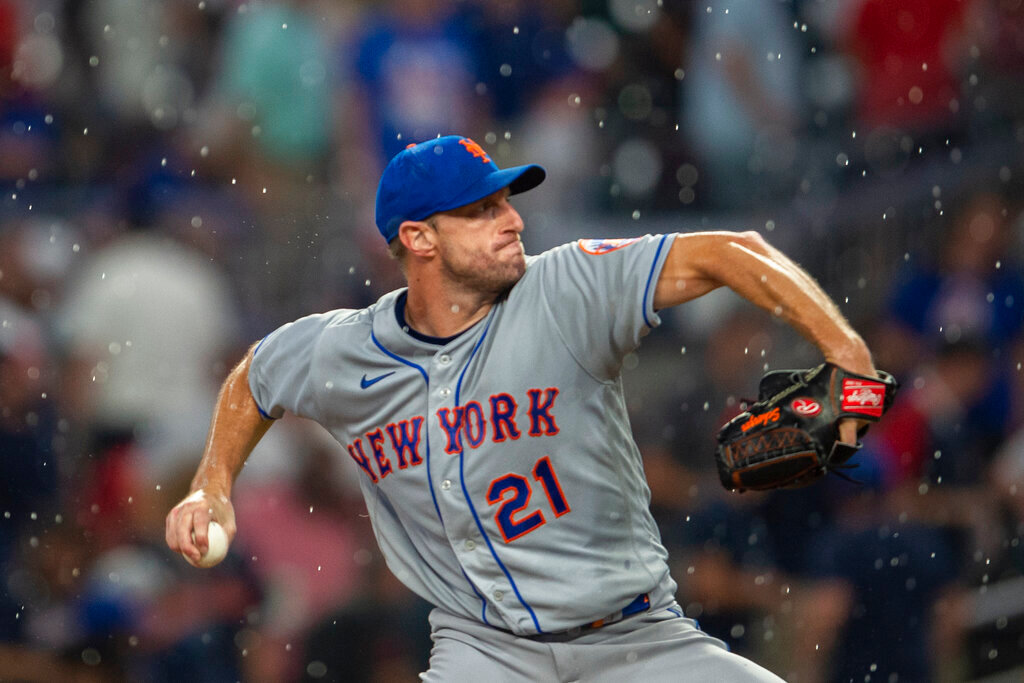 New York Mets starting pitcher Max Scherzer throws in the rain during the third inning against the Atlanta Braves on Wednesday, Aug. 17, 2022, in Atlanta. (AP Photo/Hakim Wright Sr.)