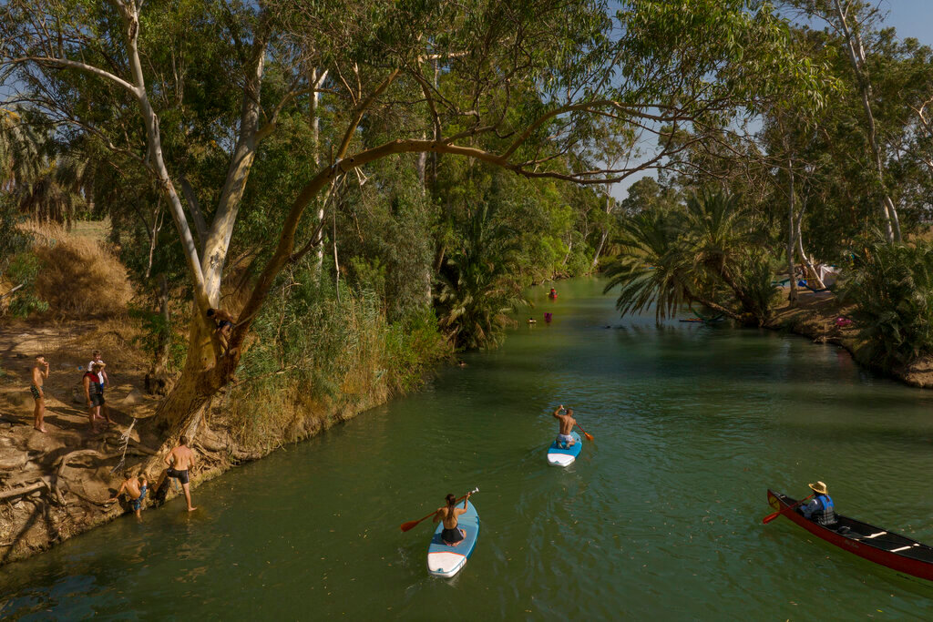People spend the day at the Jordan River near Kibbutz Kinneret in northern Israel on July 30, 2022. (AP Photo/Oded Balilty)
