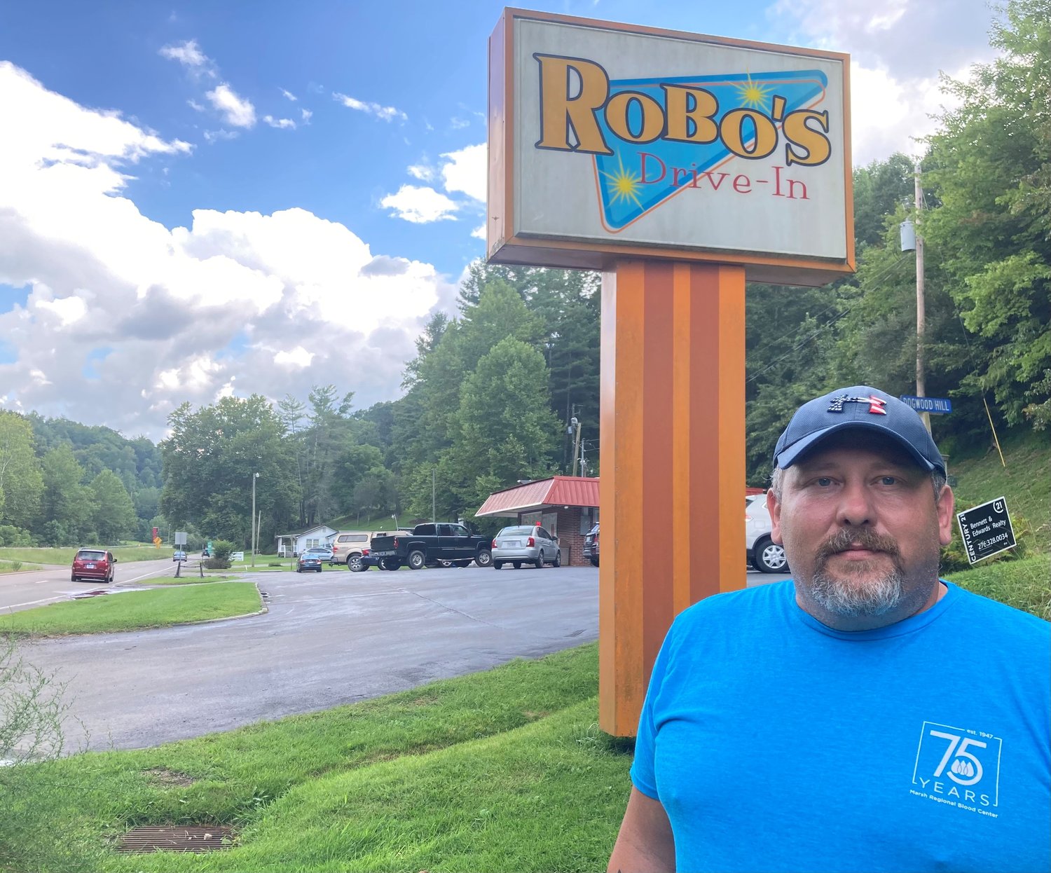 Eddie Johnson poses for a photo beneath the Robo's Drive-In restaurant sign in Pound, Va.