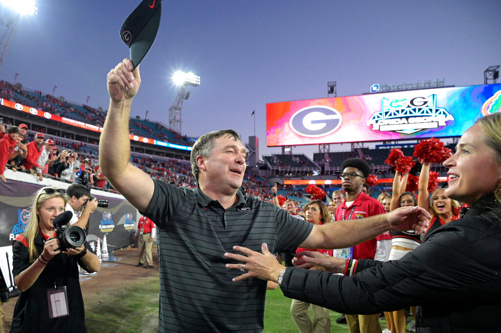 Georgia head coach Kirby Smart, center, is greeted by his wife Mary Beth Smart, right, after a win over Florida, Oct. 30, 2021, in Jacksonville, Fla. (AP Photo/Phelan M. Ebenhack, File)