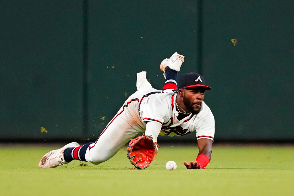Atlanta Braves center fielder Michael Harris II makes a diving attempt for a ball hit for a triple by Colorado Rockies' Brendan Rodgers during the fourth inning Tuesday, Aug. 30, 2022, in Atlanta. (AP Photo/John Bazemore)