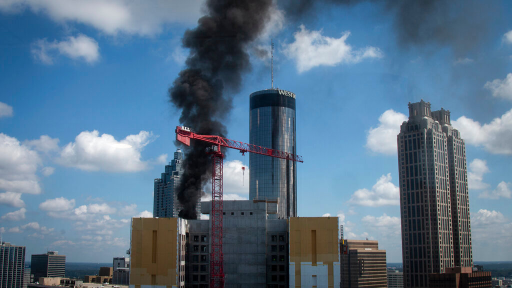 Black smoke rises from a fire atop a building under construction Wednesday, Aug. 31, 2022, in Atlanta. (AP Photo/Ron Harris)
