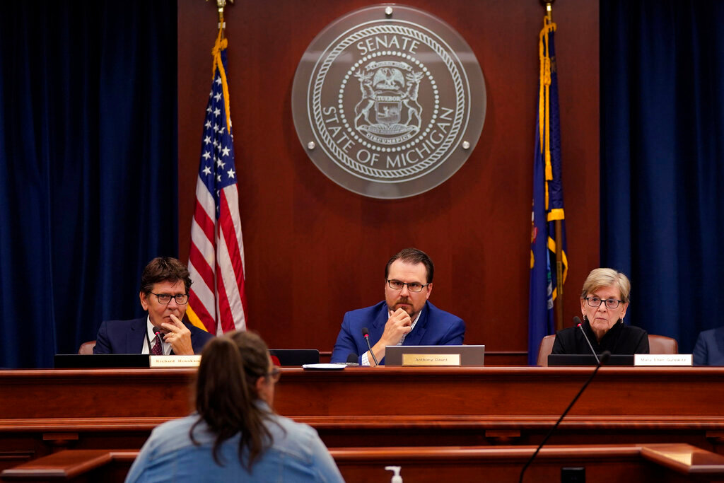 Richard Houskamp, left, Anthony Daunt and Mary Ellen Gurewitz, members of the Michigan Board of State Canvassers, listen to a speaker during a hearing Wednesday, Aug. 31, 2022, in Lansing, Mich. (AP Photo/Carlos Osorio)