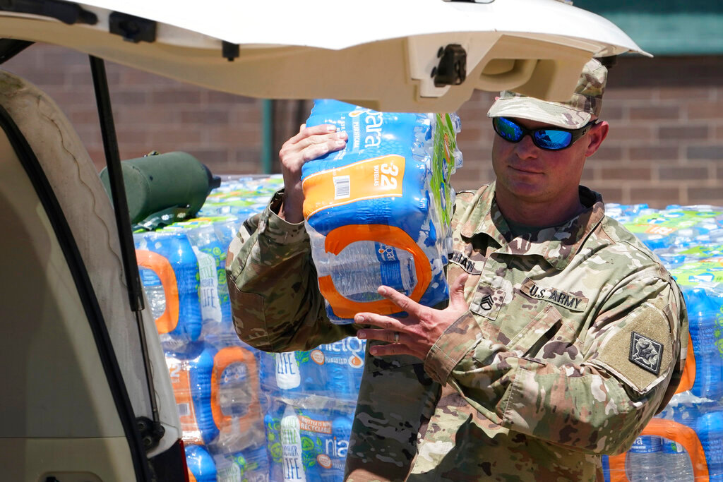A member of the Mississippi National Guard loads a vehicle as they distribute water to residents near downtown Jackson, Miss., Thursday, Sept. 1, 2022.  (AP Photo/Steve Helber)