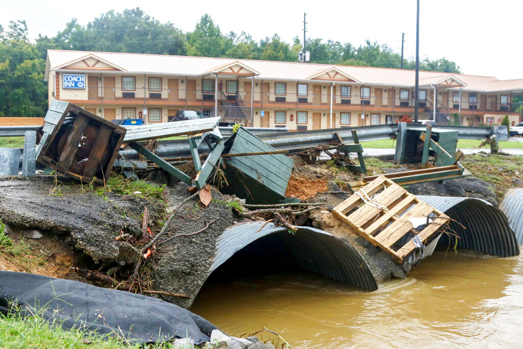 Trash cans from JR Dick Dowdy Park wash up outside of the Coach Inn Sunday, Sept. 4, 2022, in Summerville, Ga., following heavy rainfall. (Olivia Ross/Chattanooga Times Free Press via AP)