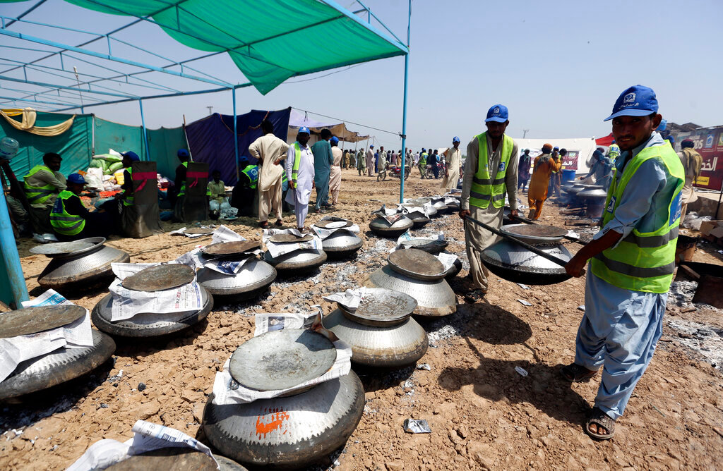 Pakistani cooks prepare food for victims of the flooding from monsoon rains, organized by the Alkhidmat Foundation, in Jaffarabad, a district of Pakistan's southwestern Baluchistan province, Monday, Sept. 5, 2022. (AP Photo/Fareed Khan)
