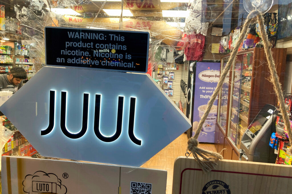 A JUUL electronic cigarette sign hangs in the front window of a bodega convenience store in New York City on June 25, 2022. (AP Photo/Ted Shaffrey, File)