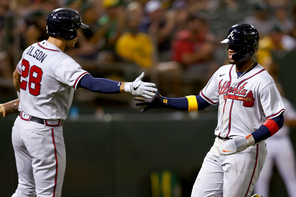Atlanta Braves' Ronald Acuna Jr., right, is congratulated by Matt Olson (28) after scoring on a sacrifice fly by Austin Riley against the Oakland Athletics during the sixth inning in Oakland, Calif., Tuesday, Sept. 6, 2022. (AP Photo/Jed Jacobsohn)