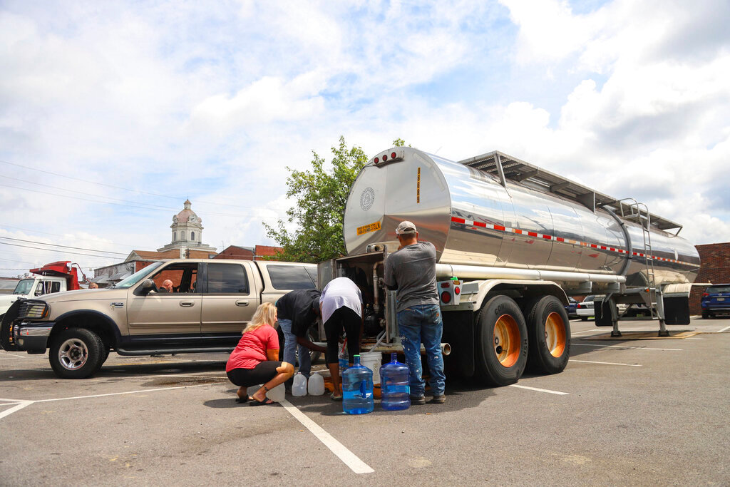 Residents fill containers from a water tanker located across from the Summerville Fire Department in Summerville, Ga., Tuesday, Sept. 6, 2022. (Olivia Ross/Chattanooga Times Free Press via AP)