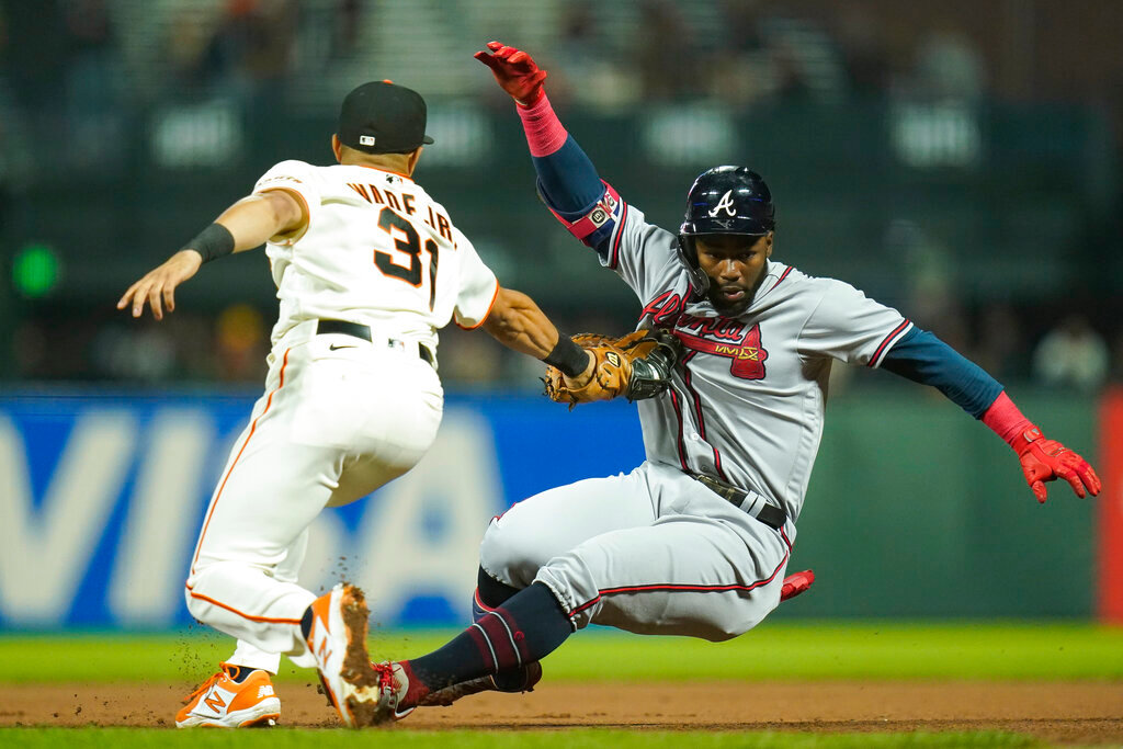 San Francisco Giants first baseman LaMonte Wade Jr. (31) tags out Atlanta Braves' Michael Harris II, who singled, at first on the throw from center fielder Lewis Brinson during the seventh inning in San Francisco, Monday, Sept. 12, 2022. Harris was caught off first after rounding the base. (AP Photo/Godofredo A. Vásquez)