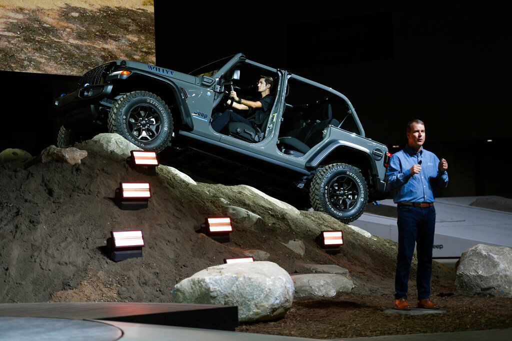 Jim Morrison, foreground, Head of Jeep Brand North America, introduces the audience to the 2023 Wrangler Willys 4XE at the North American International Auto Show, Wednesday, Sept. 14, 2022, in Detroit. (AP Photo/Jose Juarez)