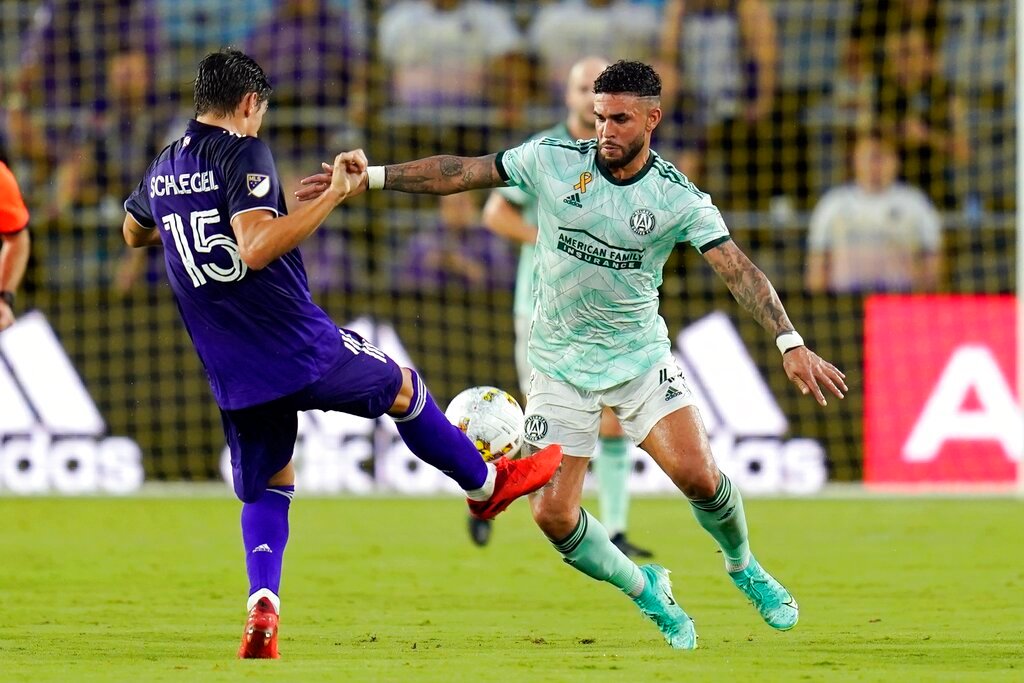 Orlando City's Rodrigo Schlegel (15) attempts to pass the ball as Atlanta United's Dom Dwyer, right, comes in to block during the first half Wednesday, Sept. 14, 2022, in Orlando, Fla. (AP Photo/John Raoux)