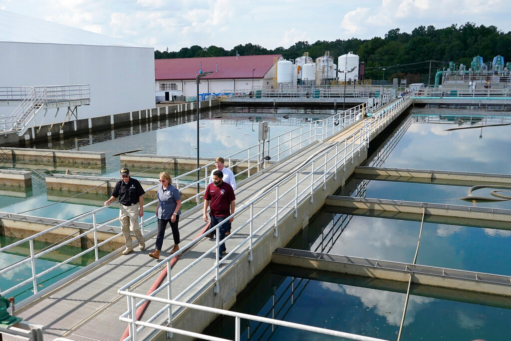 Jim Craig, with the Mississippi State Department of Health, left, leads Jackson Mayor Chokwe Antar Lumumba, right, Deanne Criswell, administrator of the Federal Emergency Management Agency (FEMA), center, and Mississippi Gov. Tate Reeves, rear, as they walk past sedimentation basins at the City of Jackson's O.B. Curtis Water Treatment Facility in Ridgeland, Miss., Sept. 2, 2022. (AP Photo/Rogelio V. Solis, File)