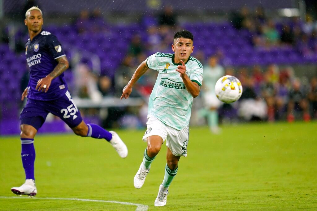 Atlanta United's Thiago Almada, right, gets position on a pass in front of Orlando City's Antonio Carlos (25) during the first half Wednesday, Sept. 14, 2022, in Orlando, Fla. (AP Photo/John Raoux)