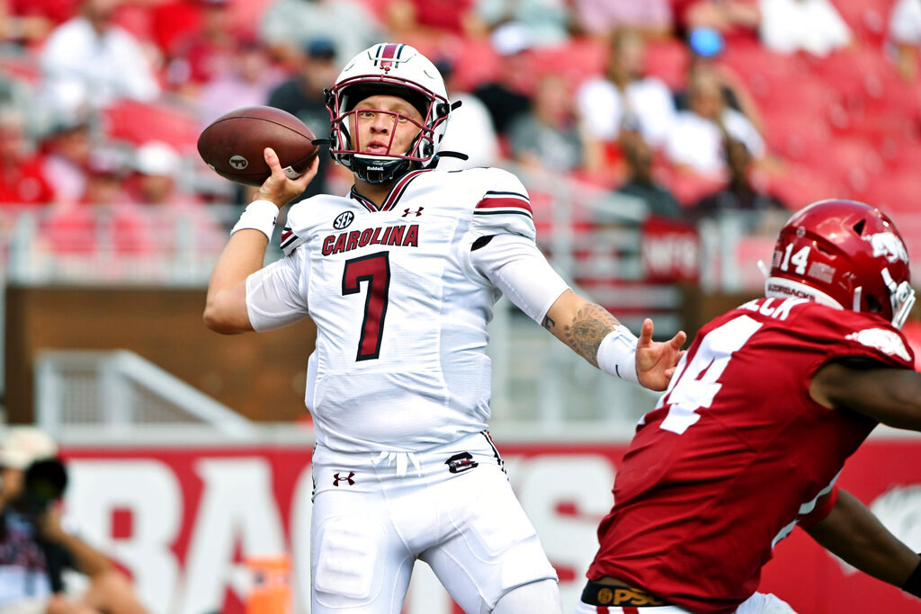 South Carolina quarterback Spencer Rattler (7) tries to throw the ball away from the end zone as he is pressured by Arkansas defenders during the second half Saturday, Sept. 10, 2022, in Fayetteville, Ark. The play resulted in a safety against South Carolina. (AP Photo/Michael Woods)