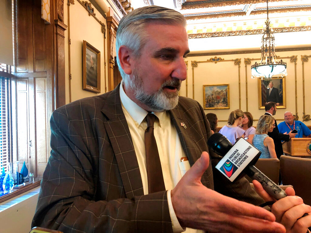 Indiana Gov. Eric Holcomb speaks with reporters following an event in his office at the Indiana Statehouse in Indianapolis, on Wednesday, Sept. 14, 2022. An Indiana judge turned down on Thursday a request to block enforcement of the ban. (AP Photo/Tom Davies)