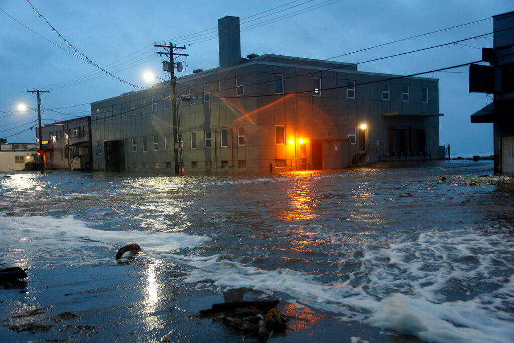 Water rushes down Front Street, just a half block from the Bering Sea, in Nome, Alaska, on Saturday, Sept. 17, 2022. (AP Photo/Peggy Fagerstrom)