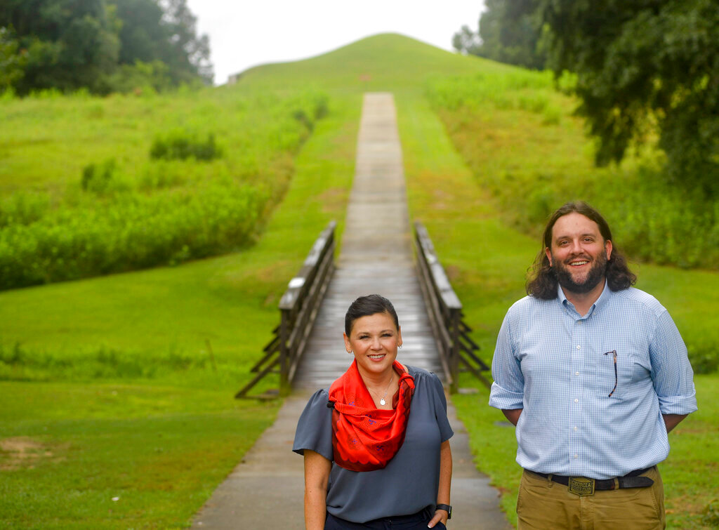 Tracie Revis, left, a citizen of the Muscogee Creek Nation, and Seth Clark, mayor pro-tem of Macon, stand at the approach to the Earth Lodge, where Native Americans held council meetings for 1,000 years until their forced removal in the 1820s, on Aug. 22, 2022, in Macon, Ga. (AP Photo/Sharon Johnson)