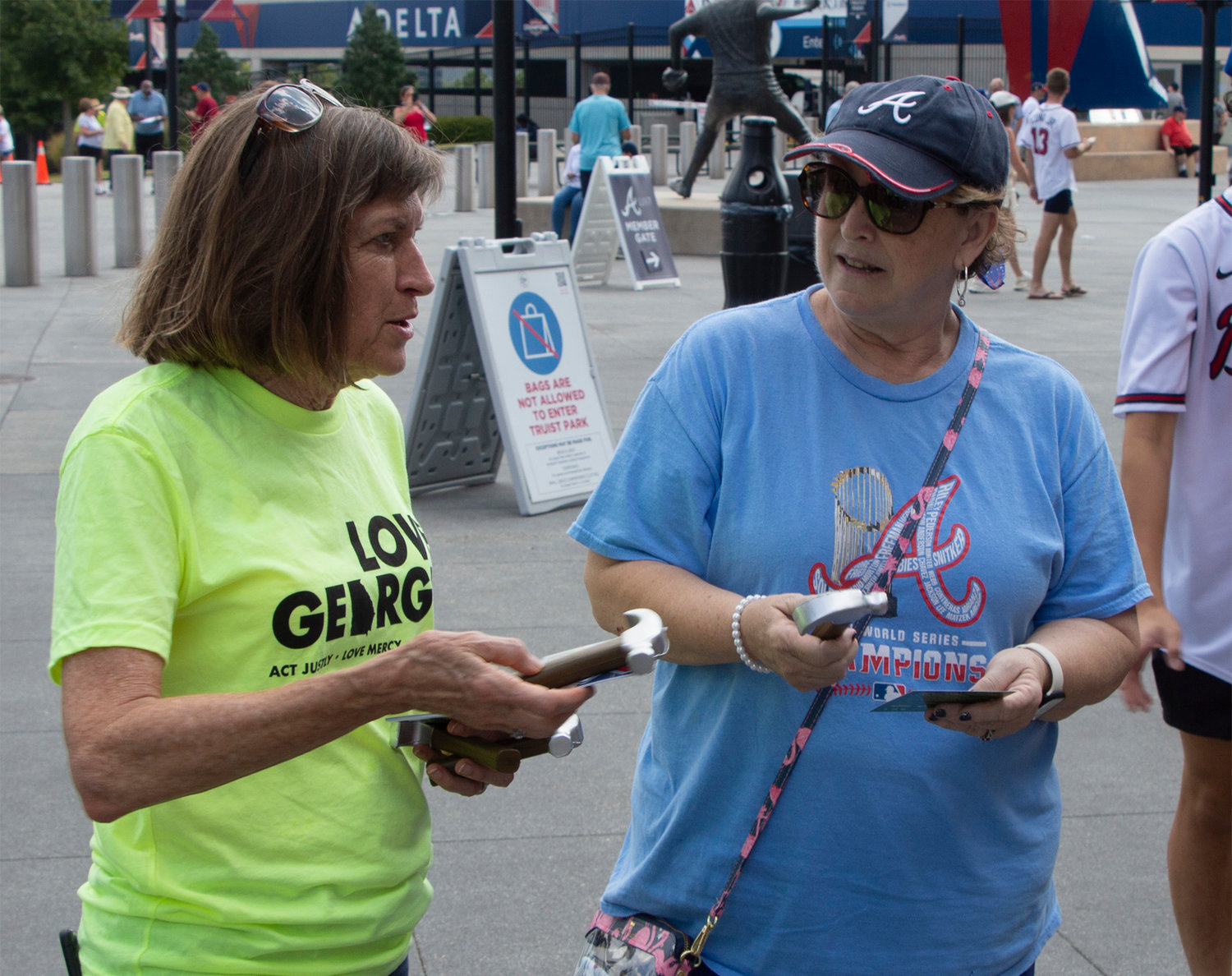 Teresa Royall, Baptist campus minister at Georgia State University, hands a hammer and pamphlet to a fan to promote Wellspring Living, which provides housing to survivors of human trafficking, prior to the Atlanta Braves game Sunday, Sept. 18, 2022, in Atlanta. (Christian Index/Henry Durand)