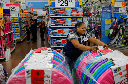 Balo Balogun labels items in preparation for a holiday sale at a Walmart Supercenter, Nov. 27, 2019, in Las Vegas.  (AP Photo/John Locher, File)