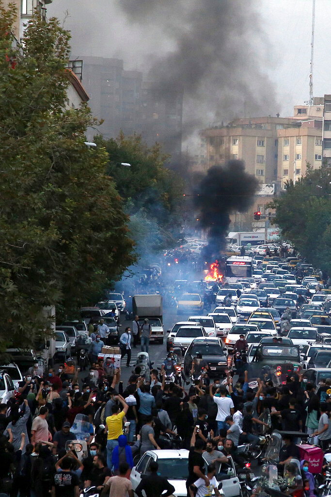 Protesters chant slogans during a protest over the death of a woman who was detained by the morality police, in downtown Tehran, Iran, Wednesday, Sept. 21, 2022. (AP Photo)