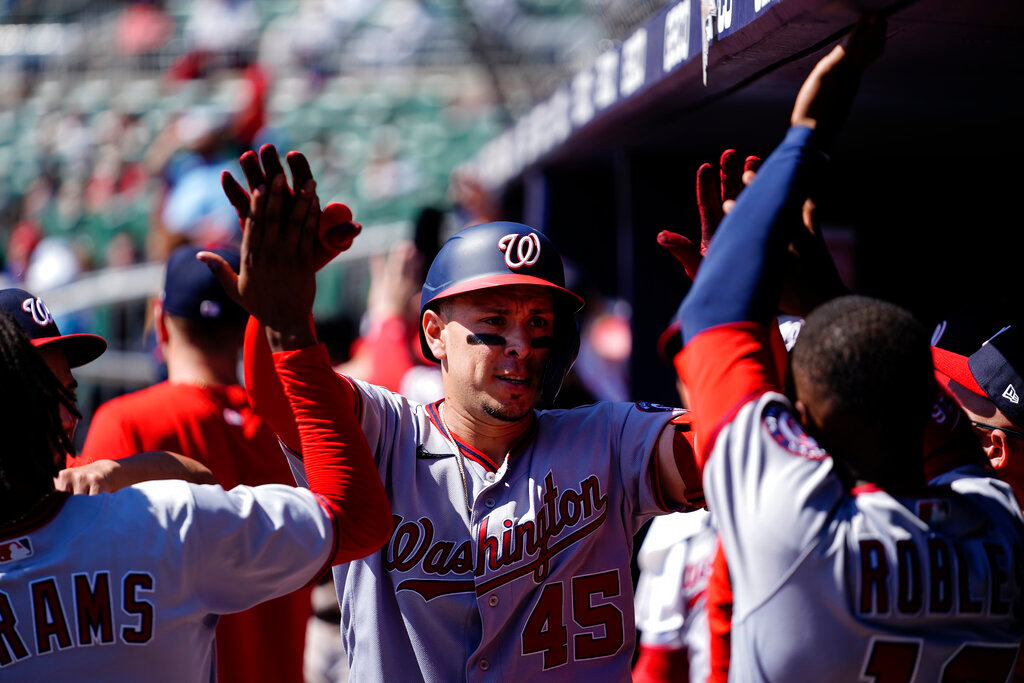 Washington Nationals' Joey Meneses (45) is greeted in the dugout after hitting a two-run home run in the seventh inning against the Atlanta Braves, Wednesday, Sept. 21, 2022, in Atlanta. (AP Photo/Brynn Anderson)