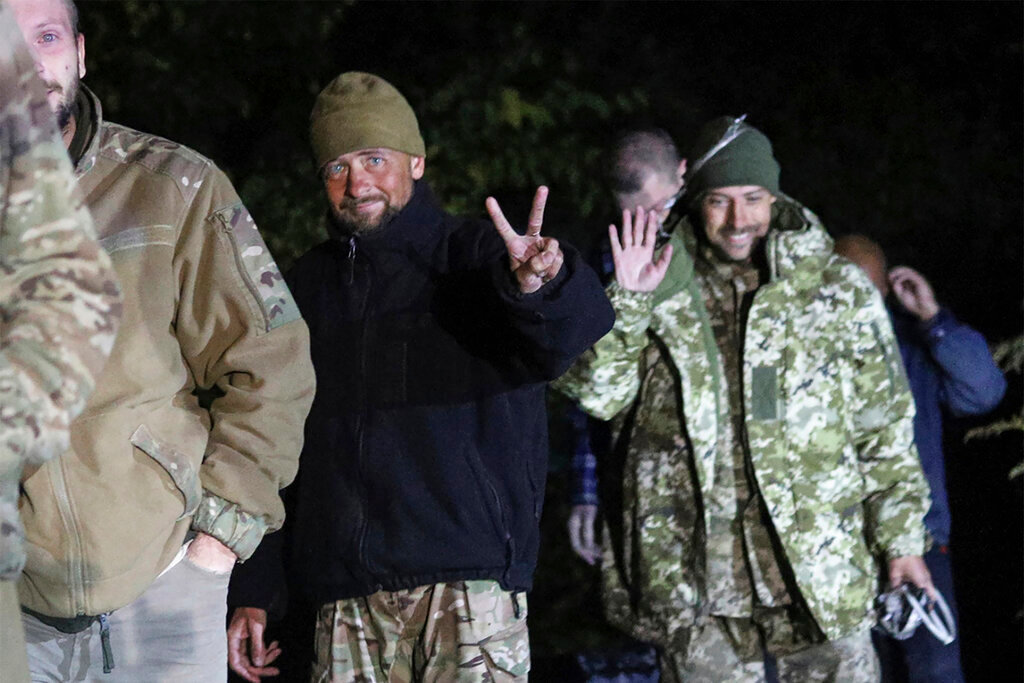 Ukrainian soldiers, who were released in a prisoner exchange between Russia and Ukraine, smile close to Chernihiv, Ukraine, late Wednesday, Sept. 21, 2022. (Ukrainian Security service Press Office via AP)