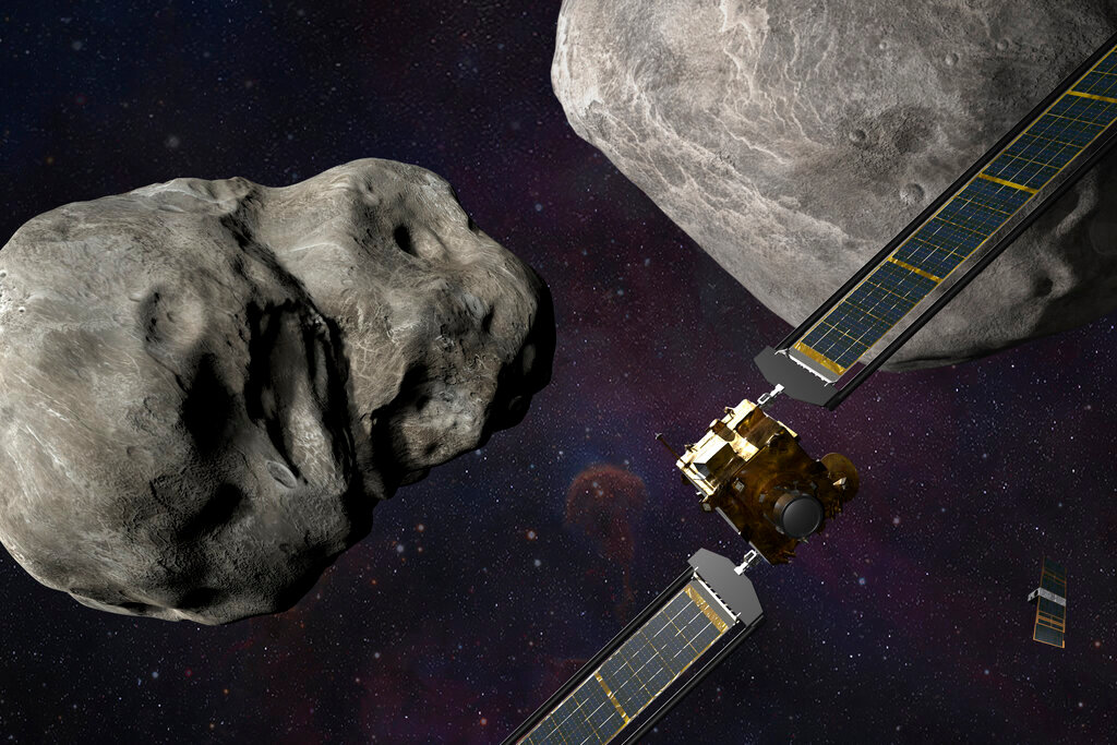 This illustration made available by Johns Hopkins APL and NASA depicts NASA's DART probe, foreground right, and Italian Space Agency's (ASI) LICIACube, bottom right, at the Didymos system before impact with the asteroid Dimorphos, left. DART is expected to zero in on the asteroid Monday, Sept. 26, 2022, intent on slamming it head-on at 14,000 mph. (Steve Gribben/Johns Hopkins APL/NASA via AP)