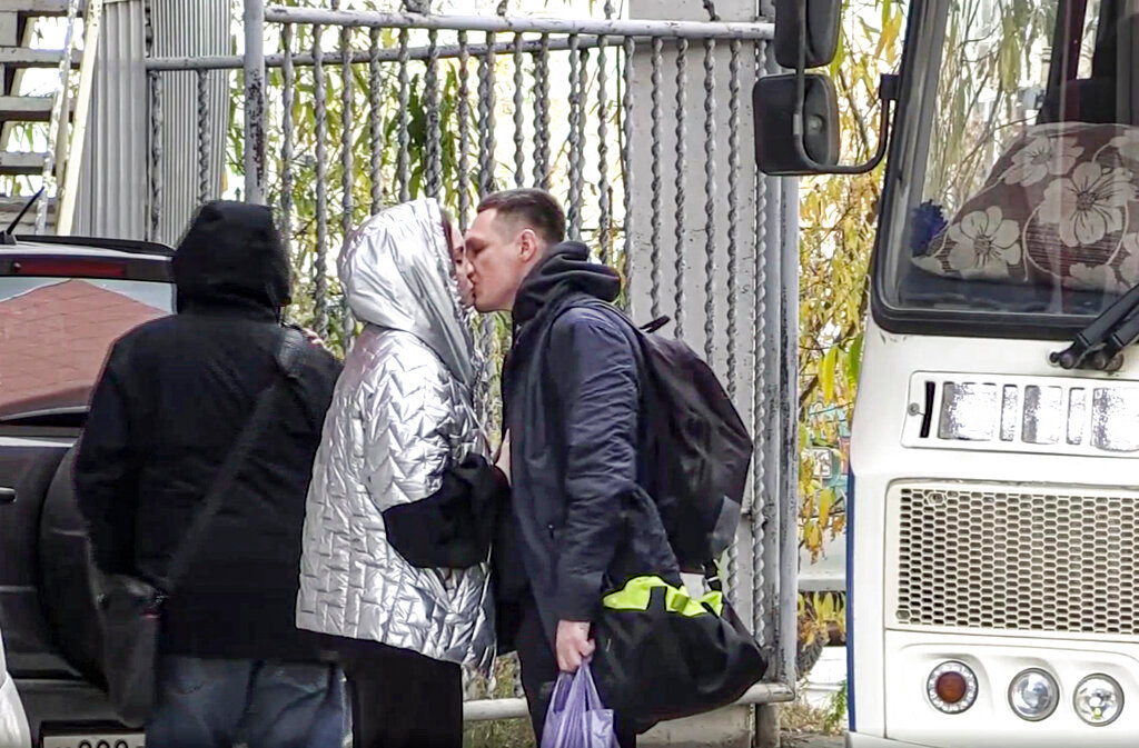 A Russian draftee kisses his partner before boarding a bus to be sent to the military units of the Eastern Military District, in Yakutsk, Russia, Friday, Sept. 23, 2022. (AP Photo)