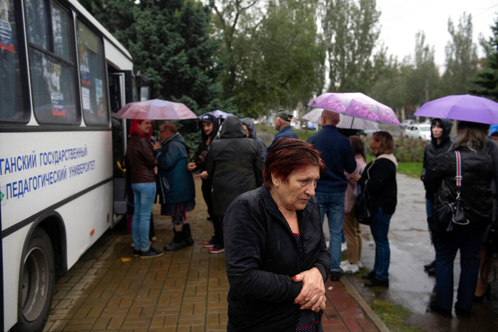 People line up to vote at a mobile polling station in Luhansk, Ukraine, Friday, Sept. 23, 2022. Voting began Friday in four regions of Ukraine on referendums to become part of Russia. (AP Photo/)