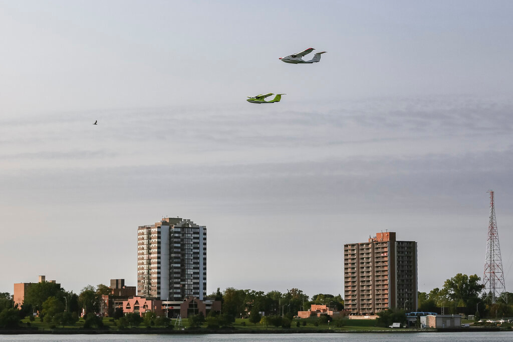 Two ICON A5 two-seat, amphibious, light-sport aircraft fly above the Detroit River in Detroit on Thursday, Sept. 15, 2022. (ICON Aircraft via AP)