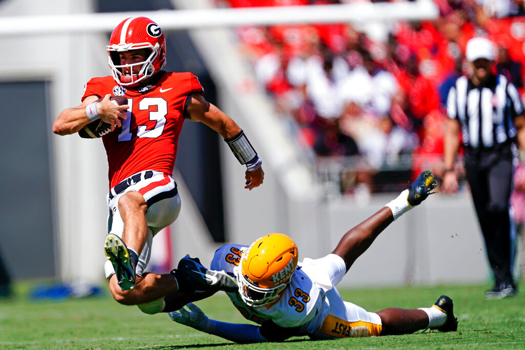Georgia quarterback Stetson Bennett (13) is tripped up by Kent State linebacker Marvin Pierre in the first half Saturday, Sept. 24, 2022, in Athens, Ga. (AP Photo/John Bazemore)