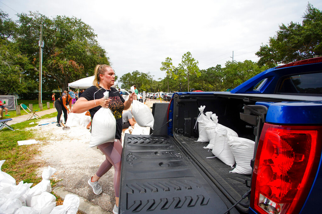 Victoria Colson of Tampa loads sandbags into her truck along with other Tampa residents who waited for more than two hours at Himes Avenue Complex to fill their ten free sandbags Sunday, Sept. 25, 2022, in Tampa, Fla. (Luis Santana/Tampa Bay Times via AP)