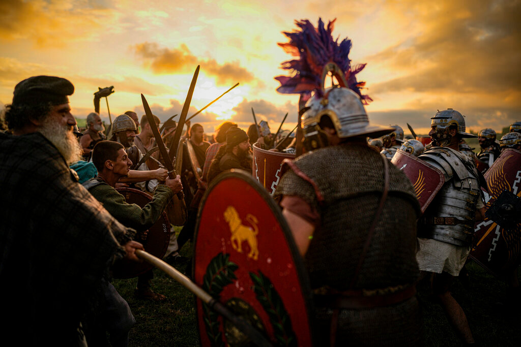 Participants in the Romula Fest historic reenactment event clash during a battle in the village of Resca, Romania, Saturday, Sept. 3, 2022. (AP Photo/Andreea Alexandru)