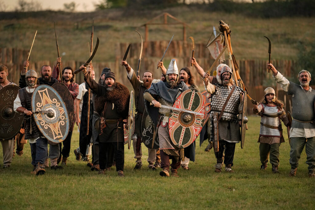 Participants in the Romula Fest historic reenactment event, depicting Dacian tribes, charge during a battle in the village of Resca, Romania, Saturday, Sept. 3, 2022. (AP Photo/Vadim Ghirda)