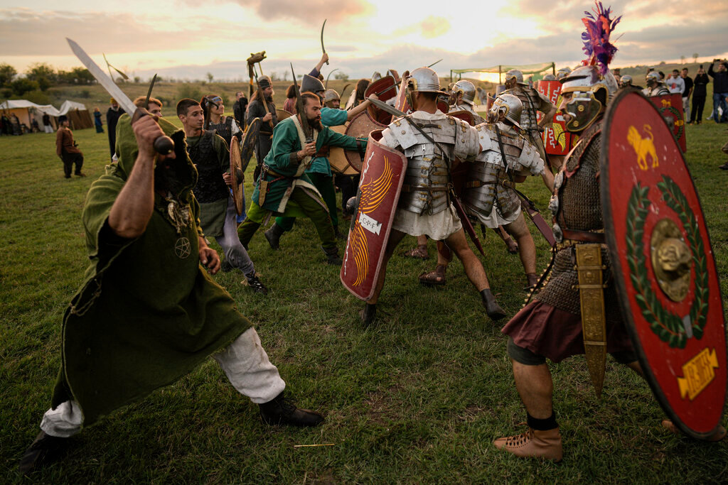 Participants in the Romula Fest historic reenactment event clash during a battle in the village of Resca, Romania, Saturday, Sept. 3, 2022. (AP Photo/Vadim Ghirda)