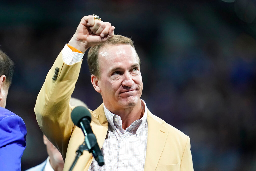 Former Indianapolis Colts player Peyton Manning holds up his Pro Football Hall of Fame commemorative ring during a game Sunday, Sept. 19, 2021, in Indianapolis. (AP Photo/Michael Conroy, File)