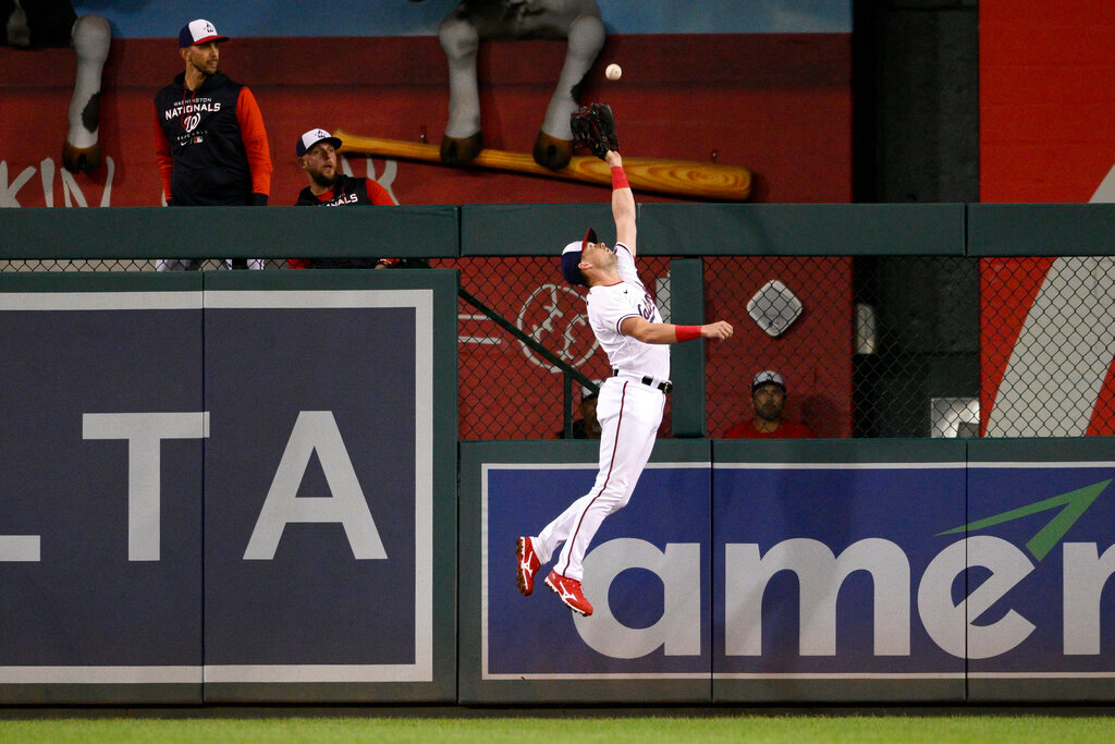 Washington Nationals right fielder Lane Thomas leaps up to make a catch on a fly ball hit by Atlanta Braves' Eddie Rosario for an out during the fourth inning Monday, Sept. 26, 2022, in Washington. (AP Photo/Nick Wass)
