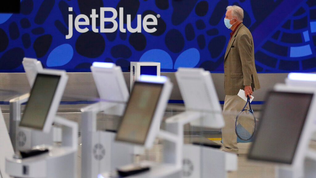 A traveler walks through the JetBlue terminal at Logan Airport in Boston, May 29, 2020. (AP Photo/Charles Krupa, File)