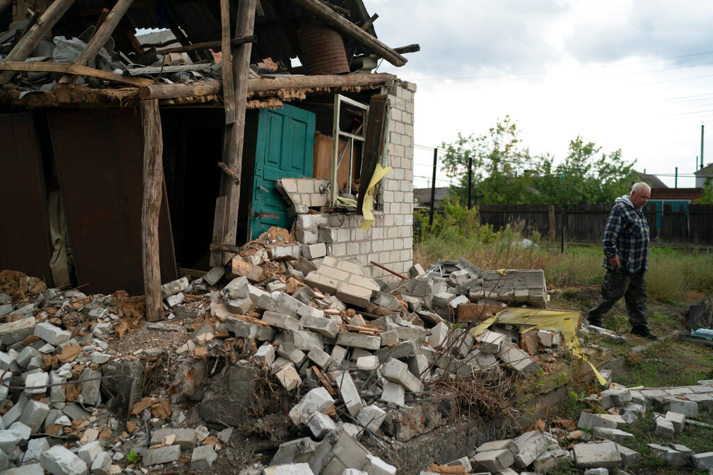 A man walks past his damaged house after a Russian attack days ago in Raihorodok, Ukraine, Monday, Sept. 26, 2022. (AP Photo/Leo Correa)