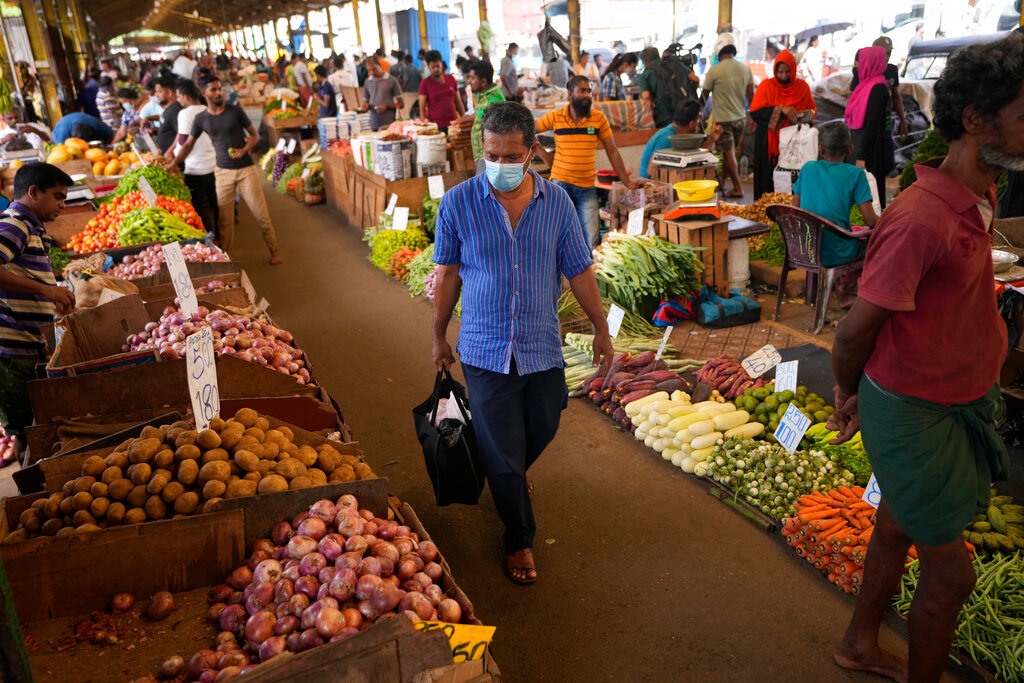 A man shops for vegetables at a market in Colombo, Sri Lanka, June 10, 2022. (AP Photo/Eranga Jayawardena, File)