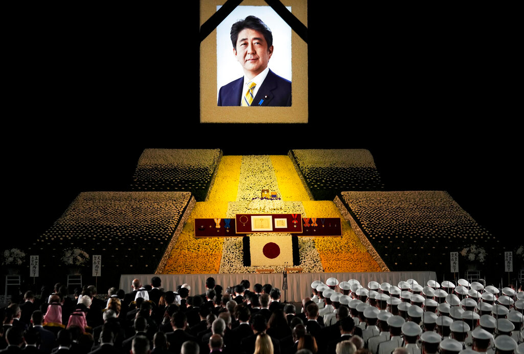 A portrait of former Japanese Prime Minister Shinzo Abe hangs on the stage during his state funeral, Tuesday, Sept. 27, 2022, Tokyo. (Franck Robichon/Pool Photo via AP)