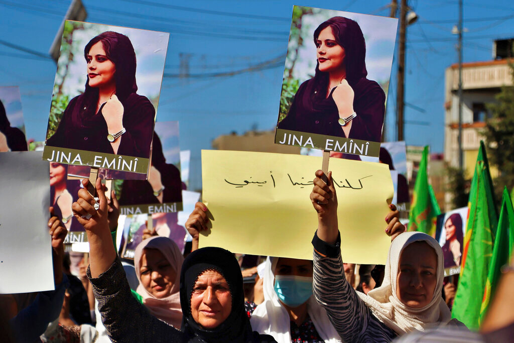 Kurdish women hold up portraits of Iranian Mahsa Amini, during a protest condemning her death in Iran, in the city of Qamishli, northern Syria, Monday, Sept. 26, 2022. (Hawar News Agency via AP via AP)