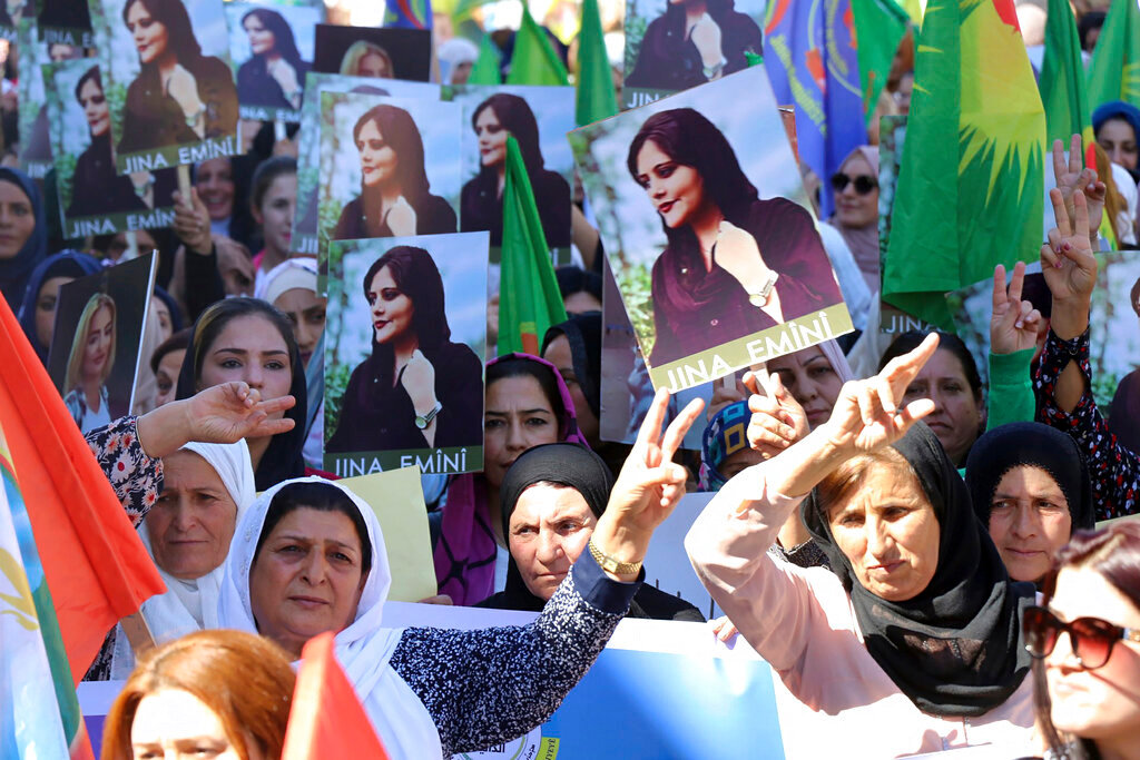 Kurdish women hold portraits of Iranian Mahsa Amini, during a protest condemning her death in Iran, in the city of Qamishli, northern Syria, Monday, Sept. 26, 2022. (Hawar News Agency via AP via AP)