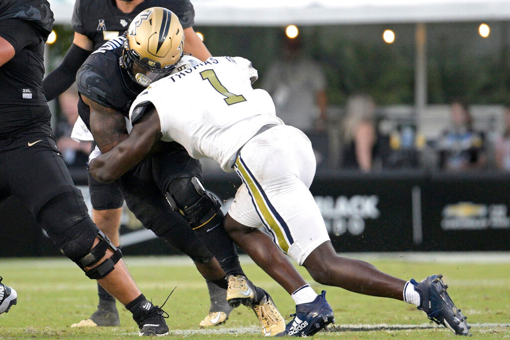 Central Florida running back RJ Harvey, left, is tackled by Georgia Tech linebacker Charlie Thomas (1) after rushing during the second half Saturday, Sept. 24, 2022, in Orlando, Fla. Thomas was penalized for targeting on the play and was disqualified from the game. (AP Photo/Phelan M. Ebenhack)