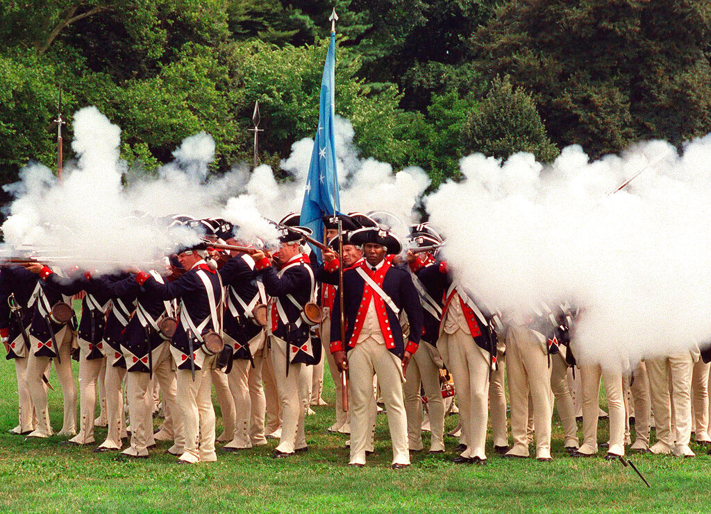 Re-enactors portraying members of the American forces during the Revolutionary War fire their rifles during a re-enactment celebrating the 225th anniversary of the Battle of Brooklyn, Aug. 18, 2001. (AP Photo/Patrick M. Reed, File)